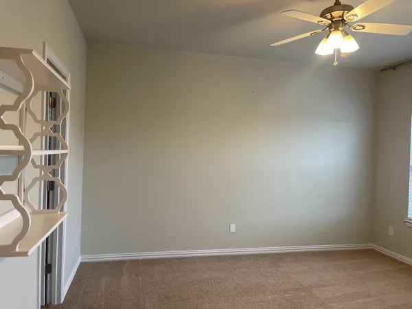 an empty room with a chandelier fan