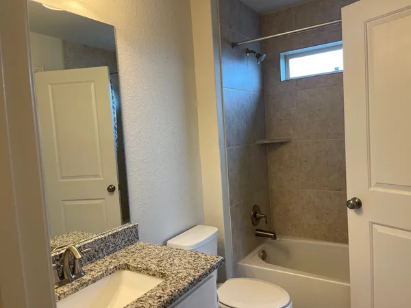 a bathroom with a granite countertop sink toilet and shower