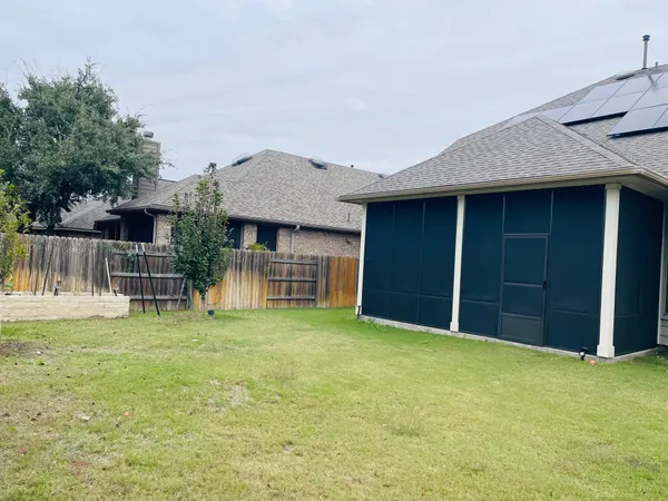 a view of a house with a yard and wooden fence
