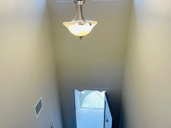 a room with a chandelier fan and a window