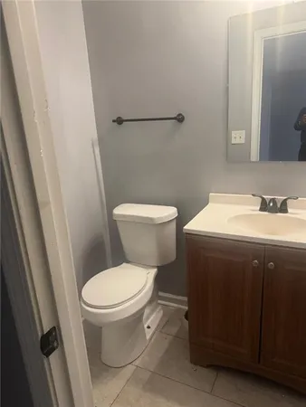 a white toilet sitting next to a sink and a mirror