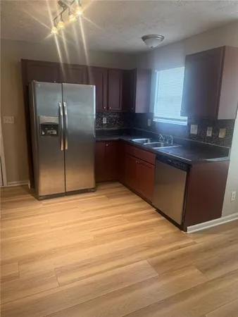 a kitchen with granite countertop a refrigerator and a sink
