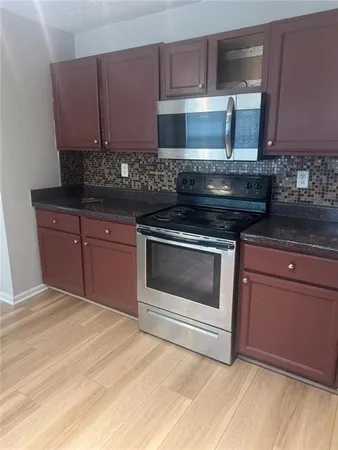 a kitchen with granite countertop wooden cabinets and stainless steel appliances