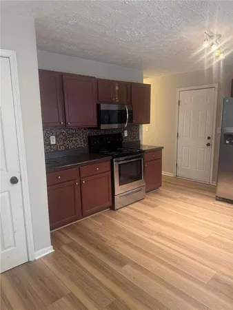 a kitchen with stainless steel appliances granite countertop a stove a sink and a microwave