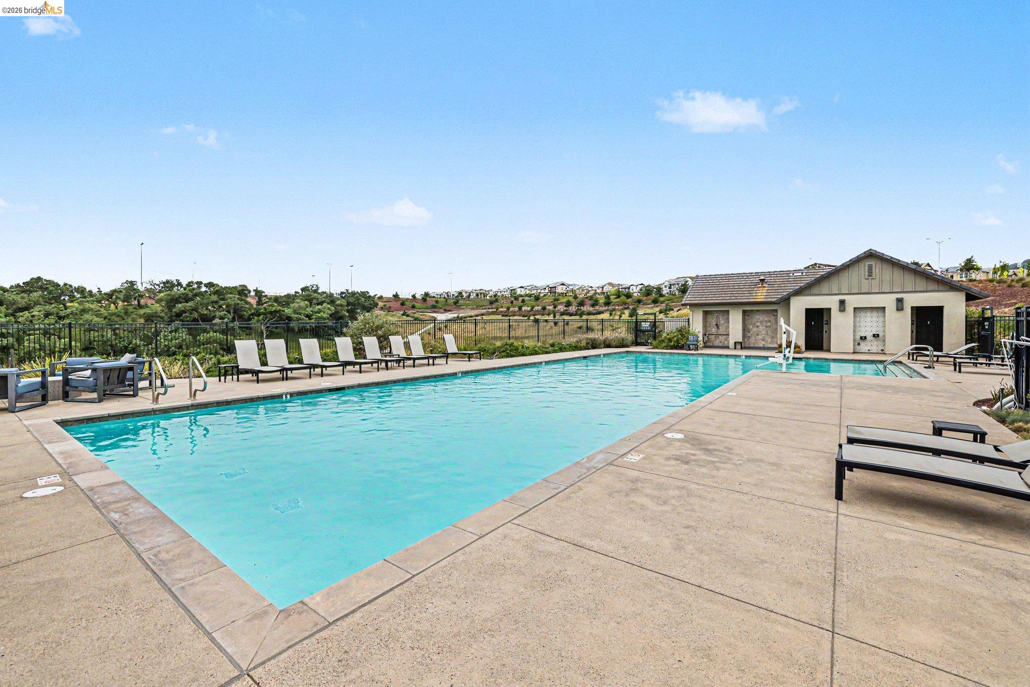 18210 Argento Loop San Ramon, CA 94583 - Photo 33 of 44 Outdoor swimming pool with concrete decking, surrounding a single-story building with a gable roof and siding
