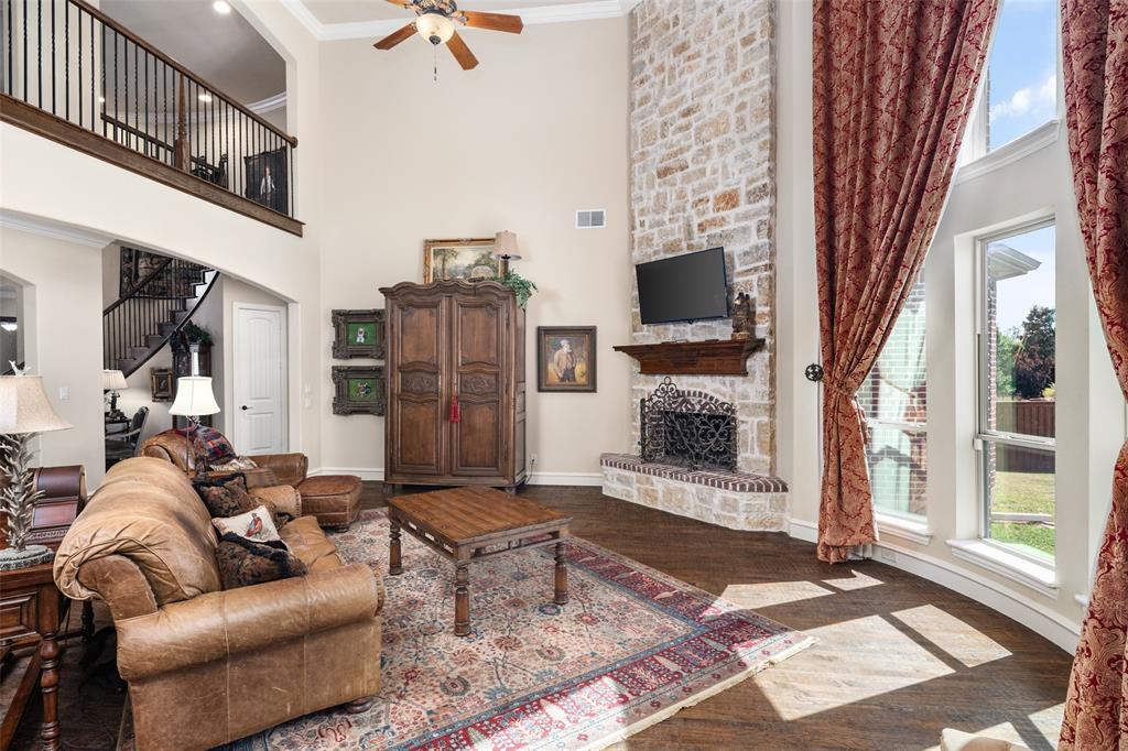 1031 Fox Bend Way Prosper, TX 75078 - Photo 11 of 40 a living room with furniture a flat screen tv and a fireplace
