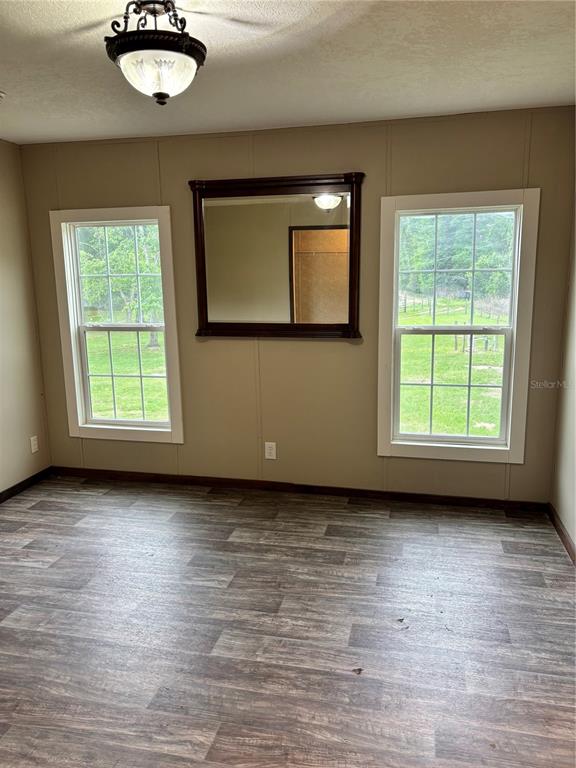 11511 Northeast 110th Road Oxford, FL 34484 - Photo 20 of 43 an empty room with wooden floor cabinet and windows
