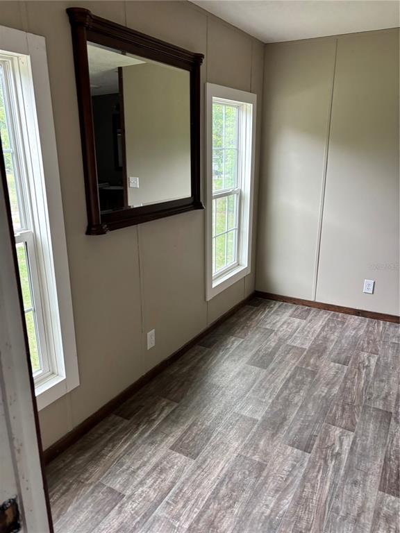 11511 Northeast 110th Road Oxford, FL 34484 - Photo 28 of 43 a view of an empty room with wooden floor and a window