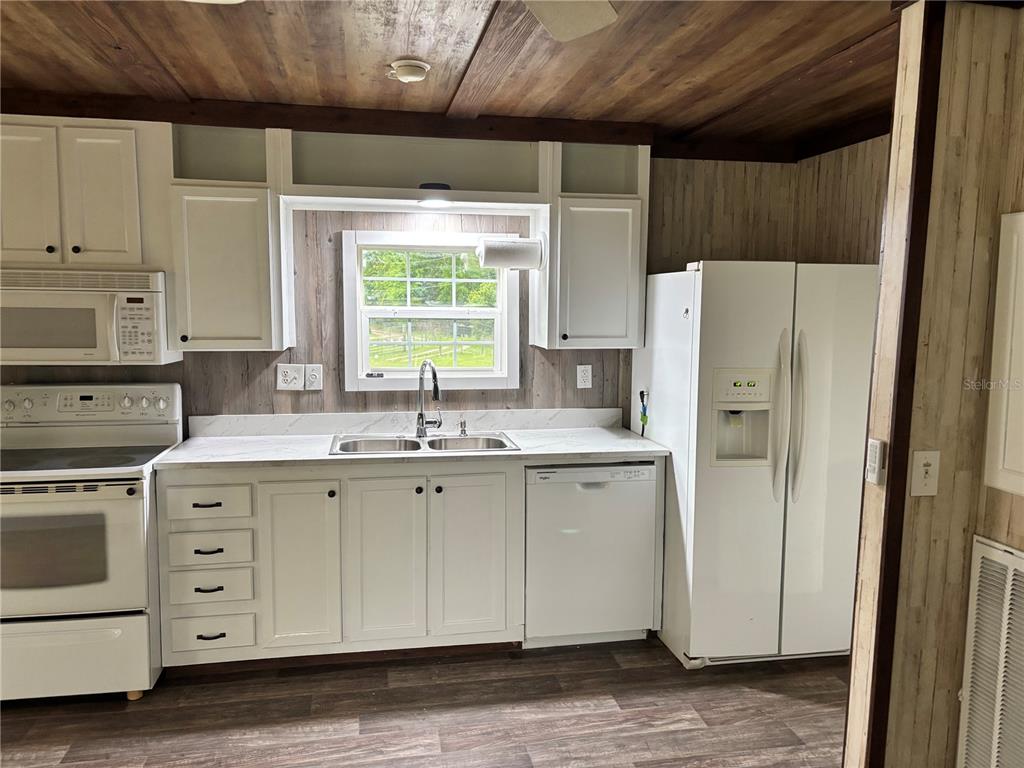 11511 Northeast 110th Road Oxford, FL 34484 - Photo 33 of 43 a kitchen with white cabinets and white appliances