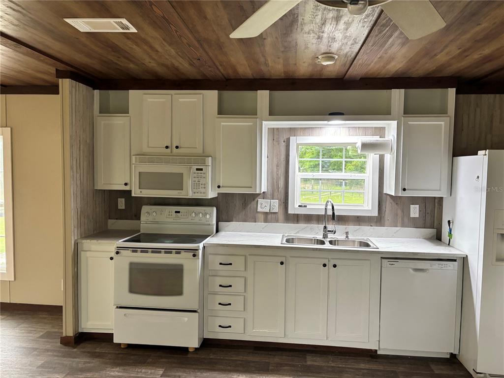 11511 Northeast 110th Road Oxford, FL 34484 - Photo 34 of 43 a kitchen with stainless steel appliances a stove a sink and white cabinets