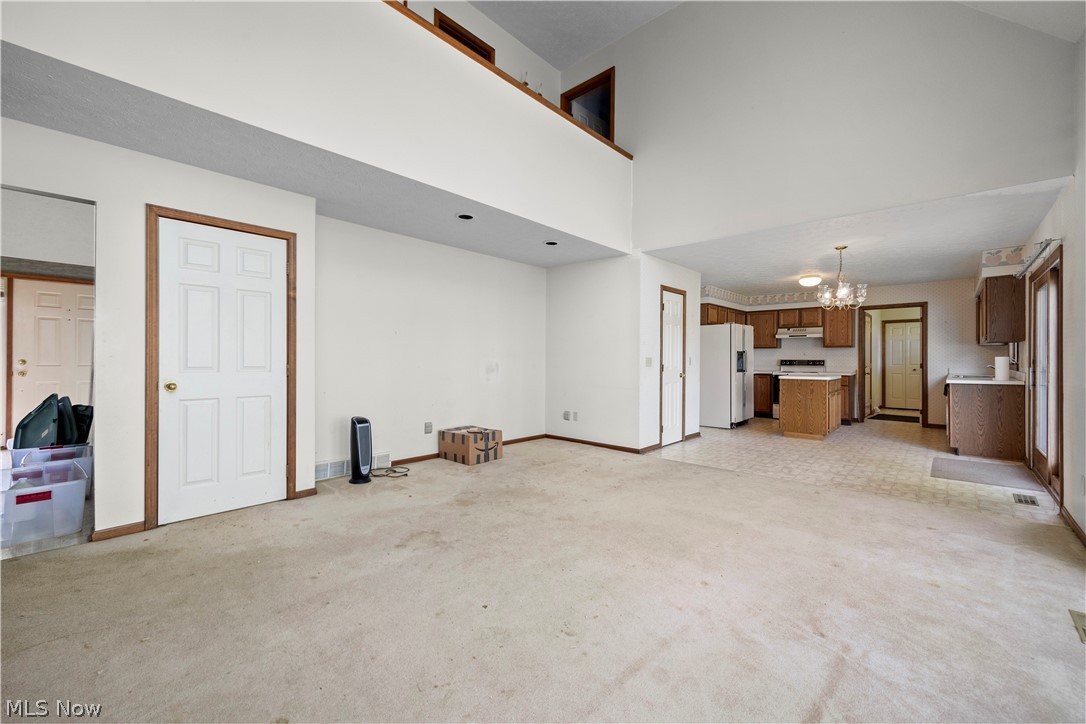 722 Jaycox Road Avon Lake, OH 44012 - Photo 3 of 48 Spacious interior featuring a vaulted ceiling, open-concept design, and a kitchen with wood cabinetry
