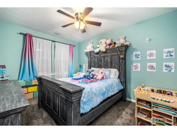 a bedroom with a bed a dresser and a chandelier