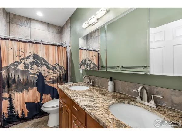 a bathroom with a granite countertop sink a toilet and a mirror