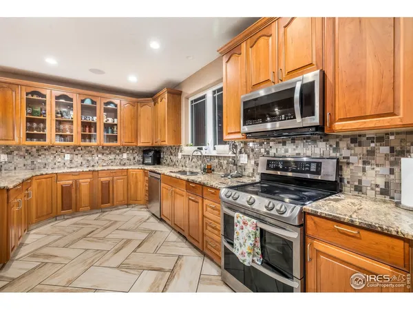 a kitchen with stainless steel appliances granite countertop a stove sink microwave and cabinets