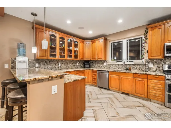 a large kitchen with granite countertop a sink and cabinets