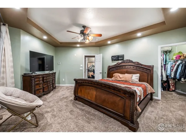 a spacious bedroom with a bed and a television