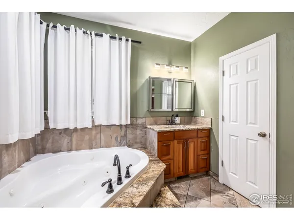 a bathroom with a bathtub a sink and a mirror