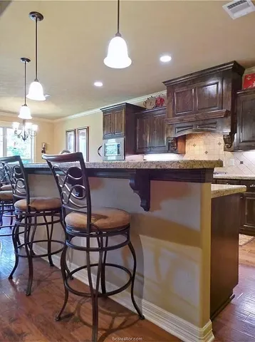 a kitchen with stainless steel appliances granite countertop a sink a stove a table and chairs