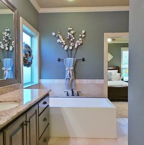 a bathroom with a granite countertop sink a large mirror and a shower