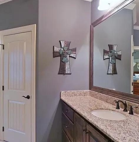 a bathroom with a granite countertop sink and a mirror