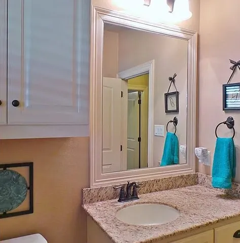 a bathroom with a granite countertop sink and a mirror