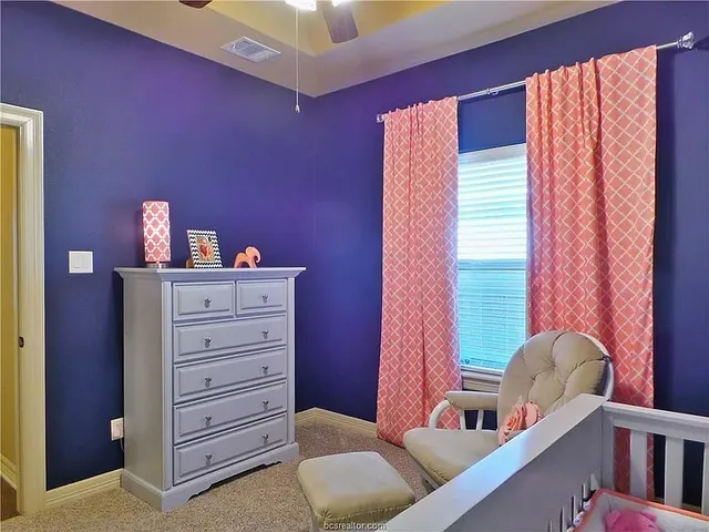 a view of a bedroom with furniture and window