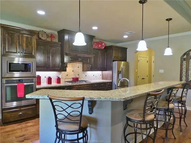 a kitchen with stainless steel appliances kitchen island granite countertop a sink and cabinets