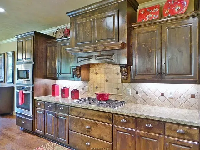 a utility room with granite countertop cabinets and stainless steel appliances