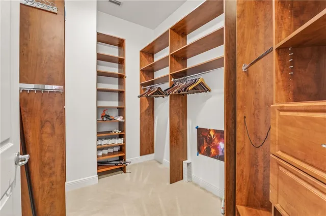 a view of walk in closet with clothes and shoes