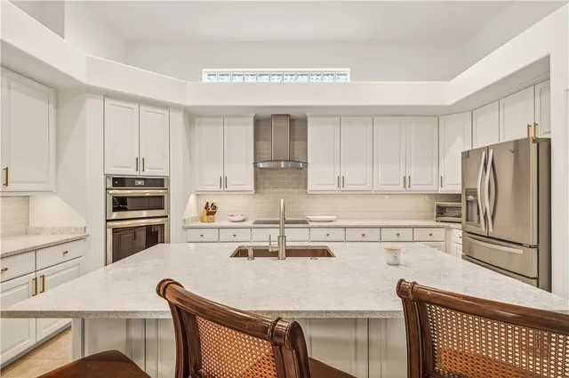 a kitchen with kitchen island a stove a sink and a refrigerator