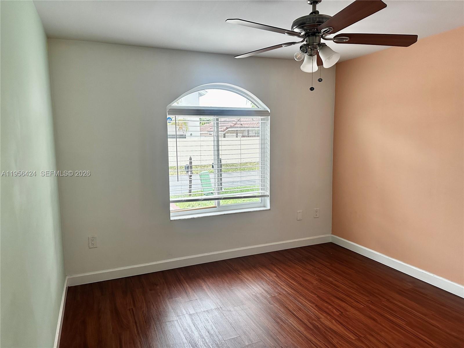 4249 Southwest 154th Avenue Miami, FL 33185 - Photo 18 of 24 an empty room with wooden floor fan and windows