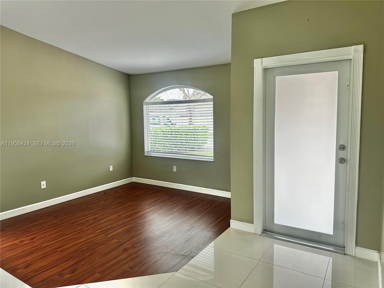 4249 Southwest 154th Avenue Miami, FL 33185 - Photo 3 of 24 an empty room with wooden floor and windows