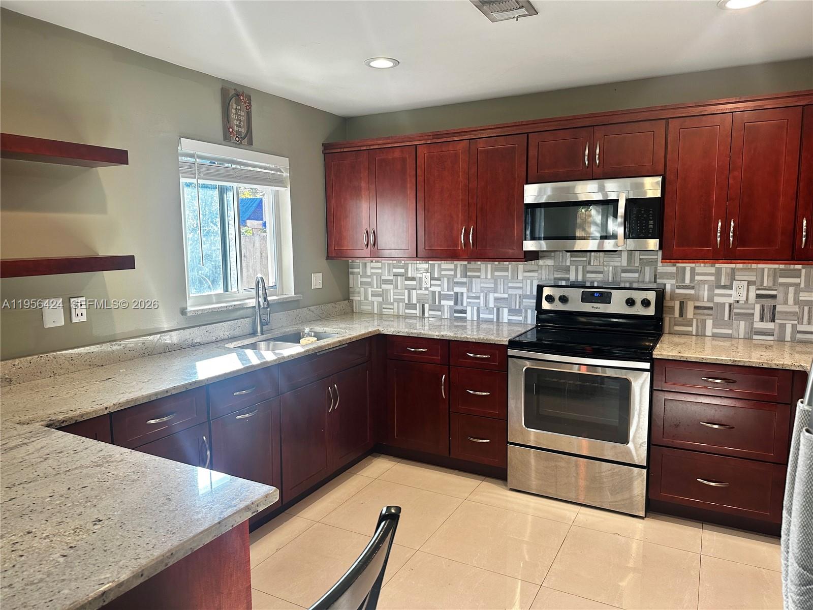 4249 Southwest 154th Avenue Miami, FL 33185 - Photo 5 of 24 a kitchen with stainless steel appliances granite countertop a sink stove and microwave