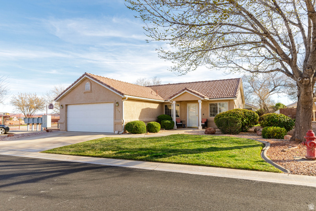 362 East 680 South Ivins, UT 84738 - Photo 1 of 1 View of front of home featuring stucco siding, driveway, a garage, a tile roof, and a front lawn