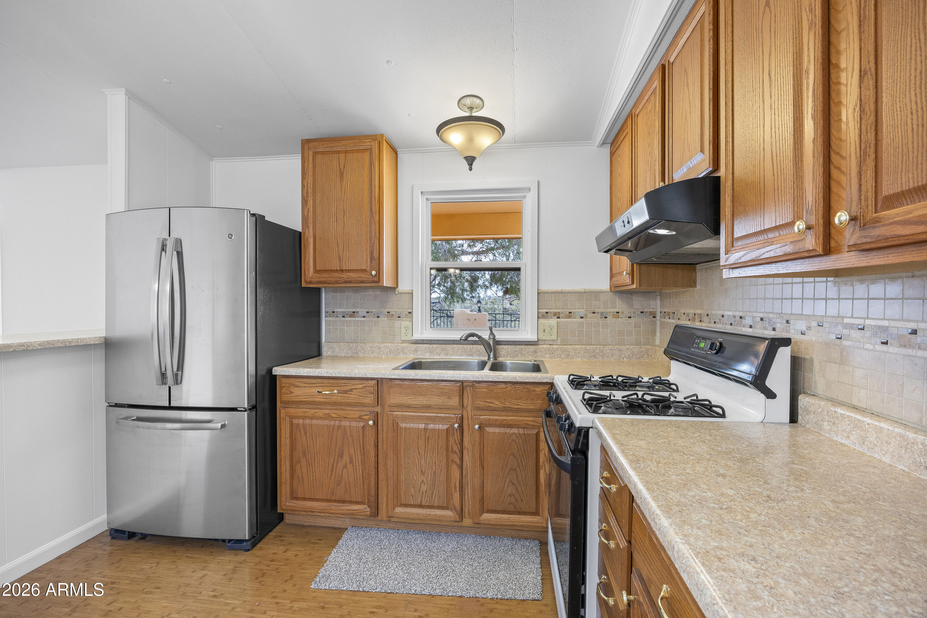 15940 North Goetz Place Tucson, AZ 85739 - Photo 15 of 37 a kitchen with a sink a refrigerator and cabinets