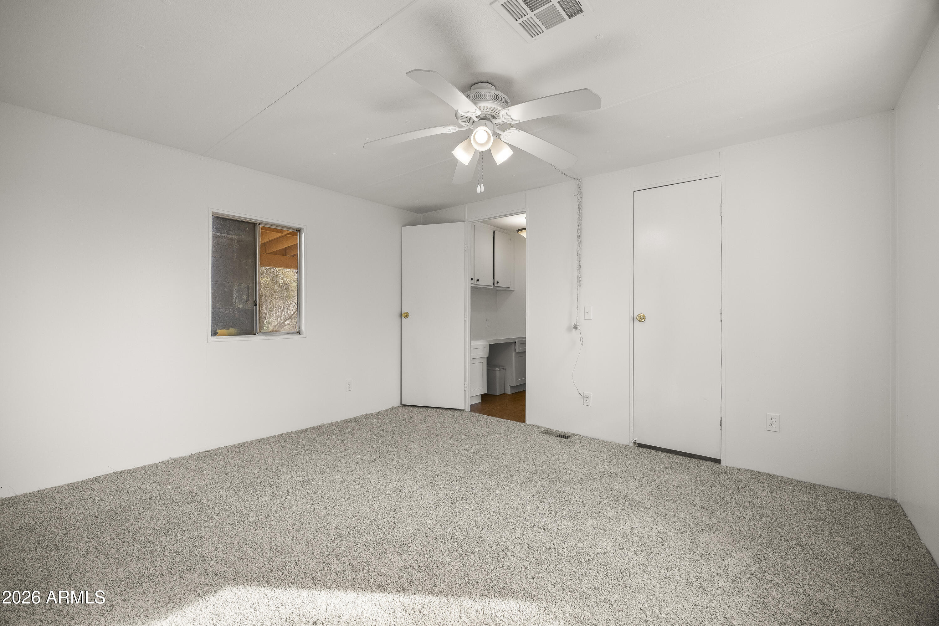 15940 North Goetz Place Tucson, AZ 85739 - Photo 25 of 37 an empty room with a ceiling fan and a window