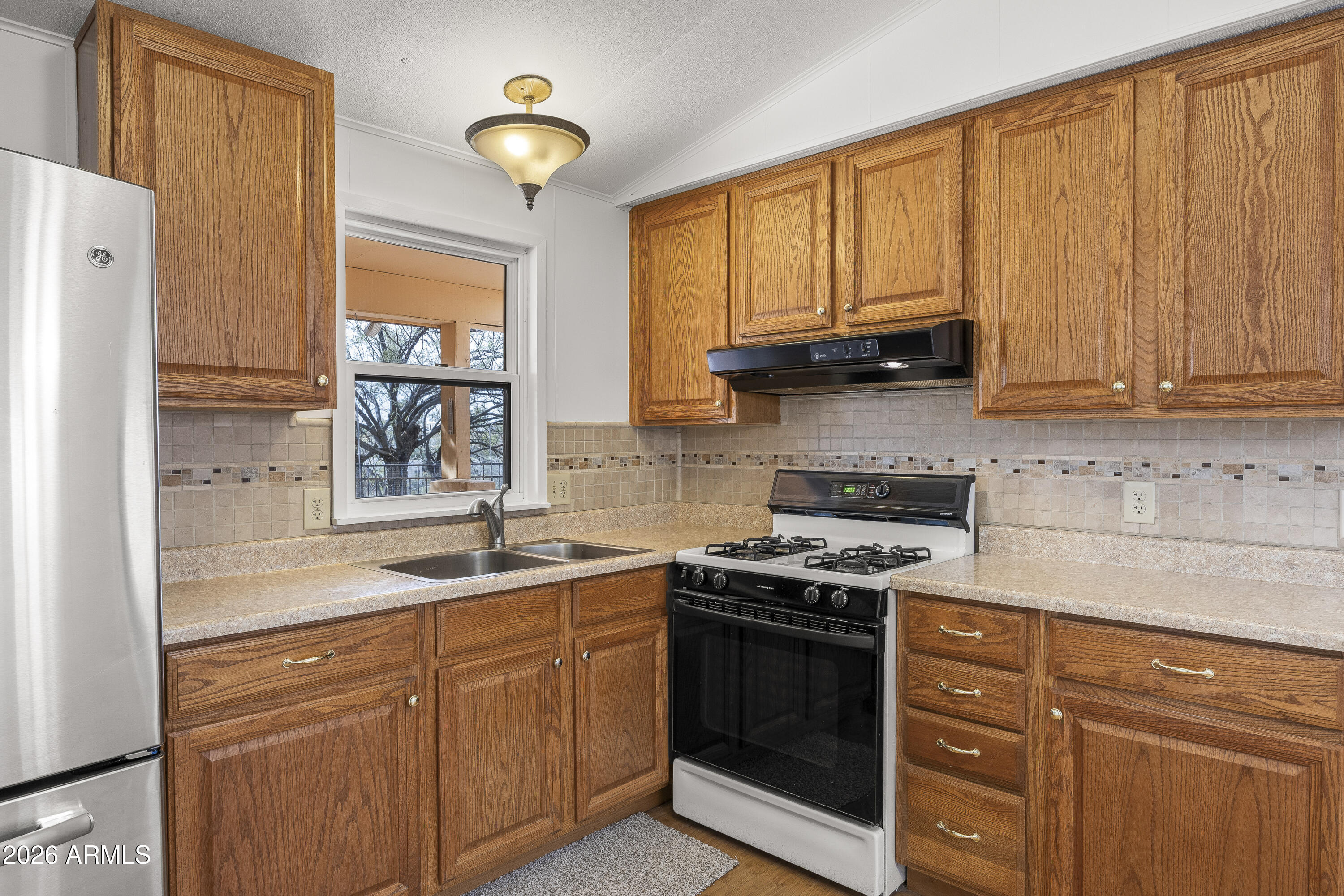 15940 North Goetz Place Tucson, AZ 85739 - Photo 4 of 37 a kitchen with stainless steel appliances granite countertop a sink stove and refrigerator
