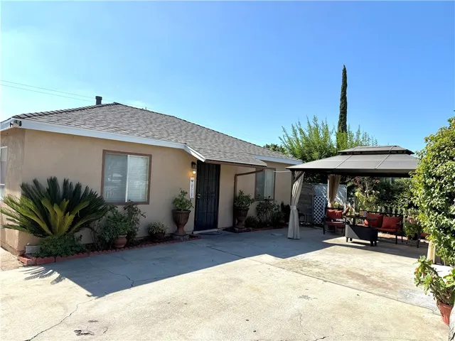 a view of a house with backyard and sitting area