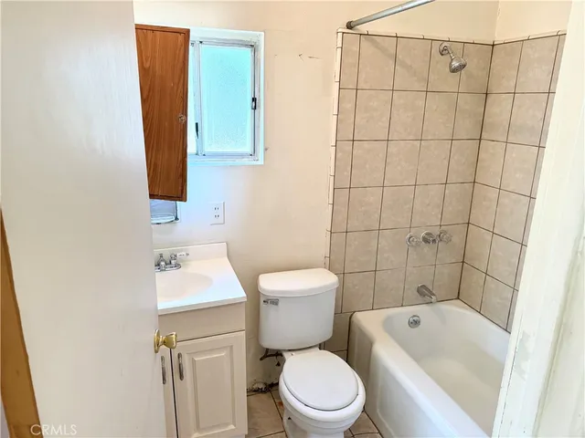 a white toilet sitting next to a bathroom sink and vanity