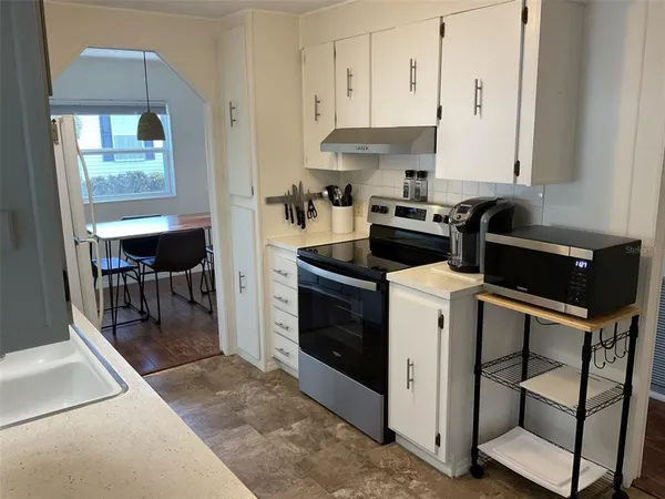 a kitchen with a stove and white cabinets