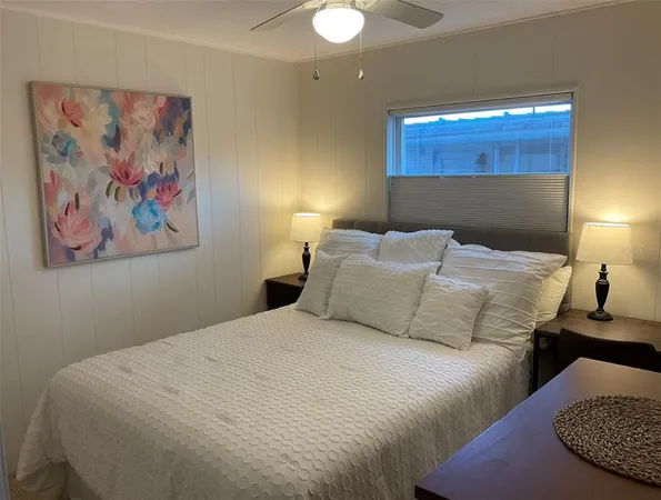 a bedroom with a bed and a painting on the wall