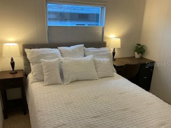 a large bed sitting in a bedroom next to a lamp