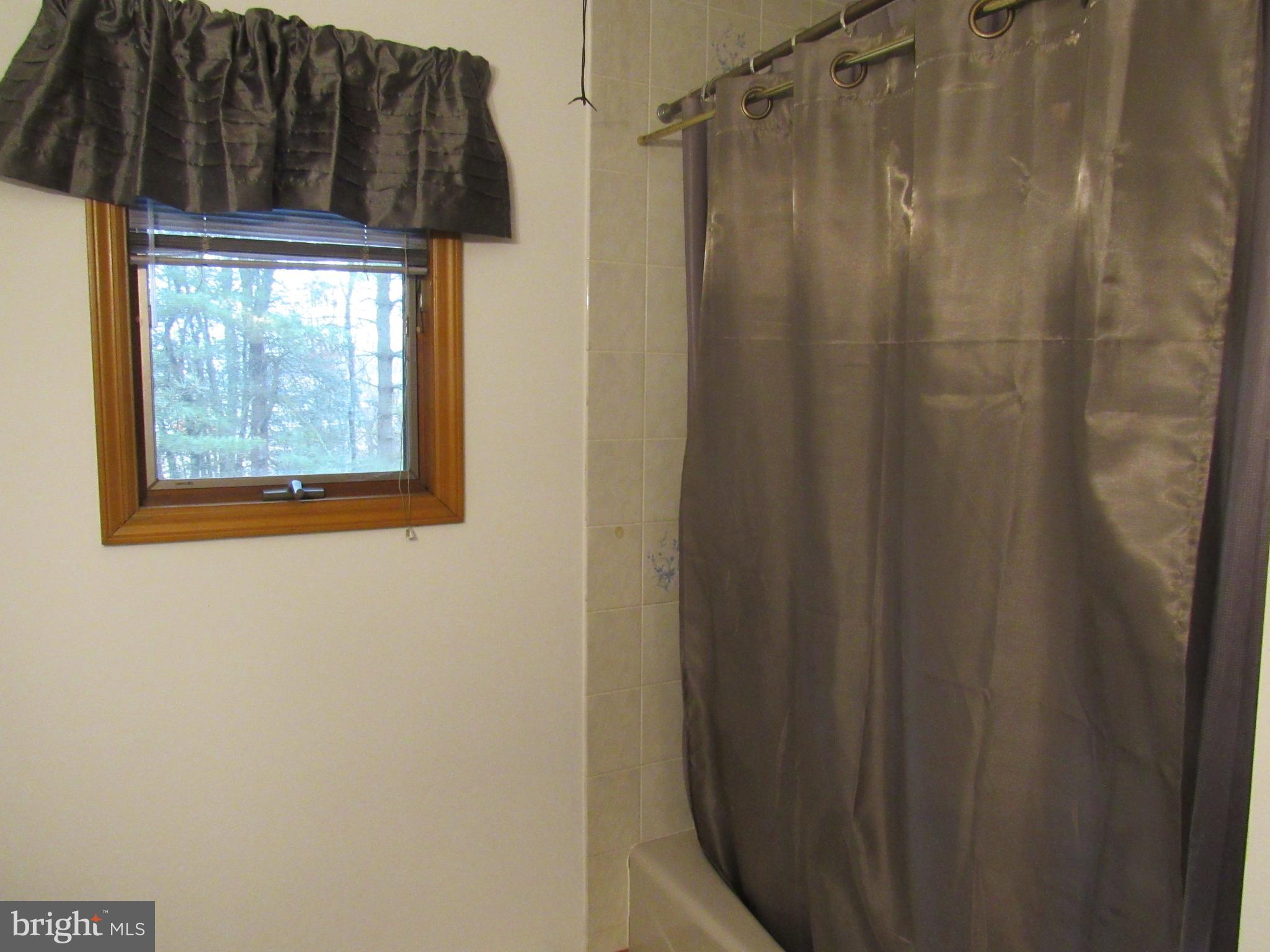 15 Cedar Grove Road Mullica Hill, NJ 08062 - Photo 32 of 41 a bathroom with a shower curtain and a window