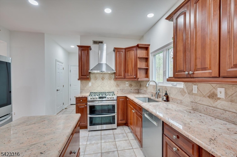 9 Stirrup Way Princeton, NJ 08540 - Photo 16 of 50 a kitchen with stainless steel appliances granite countertop a sink stove and cabinets
