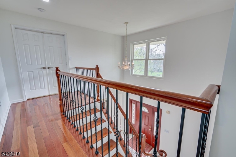 9 Stirrup Way Princeton, NJ 08540 - Photo 26 of 50 a view of a hallway with wooden floor and stairs