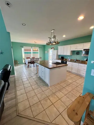a kitchen with stainless steel appliances kitchen island granite countertop a sink and a white cabinets