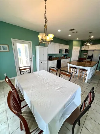 a kitchen with kitchen island a stove and a chandelier
