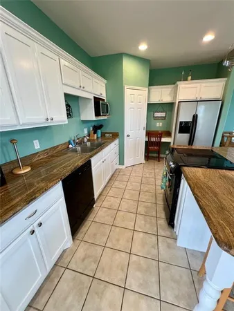 a kitchen with stainless steel appliances granite countertop a stove a sink a counter top space and cabinets