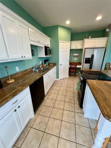 a kitchen with stainless steel appliances granite countertop a stove a sink a counter top space and cabinets