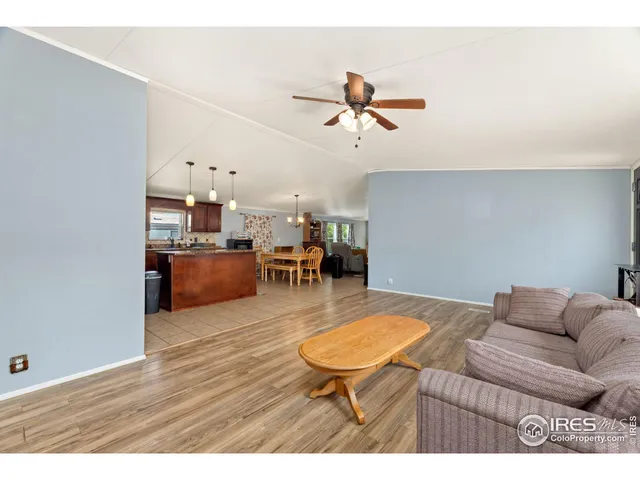 a living room with furniture and a view of kitchen
